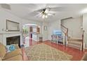 Cozy living room with wood floors, fireplace, ceiling fan, and view of the kitchen at 1007 Denmark Manor Dr, Morrisville, NC 27560