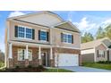 Two-story home with stone veneer, a two-car garage, and a well-maintained lawn, side view at 112 Pisgah St, Sanford, NC 27330