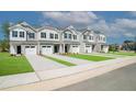 Street view of new townhomes with paved driveways, green grass, and attractive architectural details, creating a welcoming community at 129 Rolesville Ridge Dr, Rolesville, NC 27571