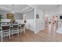 Elegant dining room with hardwood floors, wainscoting, and a modern chandelier at 1530 Armscroft Ln, Apex, NC 27502