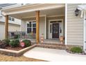 Cozy covered front porch with brick accents and space for seating at 1530 Armscroft Ln, Apex, NC 27502