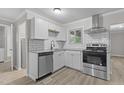 Modern kitchen features stainless steel appliances, granite counters, white cabinets, and a subway tile backsplash at 1706 Us Hwy 70A E, Hillsborough, NC 27278