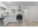 Modern kitchen features stainless steel appliances, granite counters, white cabinets, and a subway tile backsplash at 1706 Us Hwy 70A E, Hillsborough, NC 27278