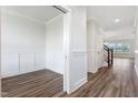 Bright hallway with elegant trim, hardwood flooring, and an open doorway leading to an adjacent room at 1785 Birdhaven Ln, Wendell, NC 27591