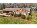 Attractive brick home showcasing neat landscaping with mulch beds and evergreen shrubs for added character at 1837 Shamrock Dr, Burlington, NC 27215