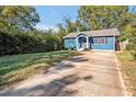 Quaint blue home featuring a concrete driveway, manicured lawn, and a cozy front porch at 206 Justice Heights St, Apex, NC 27502