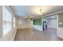 Bright living room featuring light hardwood floors, a ceiling fan, and white wainscoting at 206 Justice Heights St, Apex, NC 27502