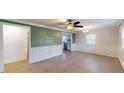 Open living room with a ceiling fan, hardwood floors, and white chair rail molding at 206 Justice Heights St, Apex, NC 27502