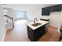 Modern kitchen with island, stainless steel appliances, and adjacent living space at 2335 Whitewing Ln, Wendell, NC 27591