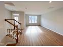 Open-concept living room with wood flooring, staircase, and lots of natural light at 2335 Whitewing Ln, Wendell, NC 27591