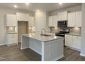Modern kitchen with stainless steel appliances, white cabinets, and a granite-topped island at 338 Tormore Dr, Homesite 123, Sanford, NC 27330