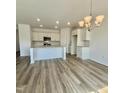 Open kitchen and dining area featuring an island with granite countertops and modern lighting at 338 Tormore Dr, Homesite 123, Sanford, NC 27330
