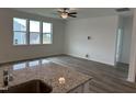 Open-concept living room with hardwood floors, bright windows, and an open concept view to the kitchen at 338 Tormore Dr, Homesite 123, Sanford, NC 27330