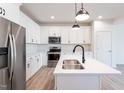 Modern kitchen with stainless steel appliances, white cabinets, and a central island with a sink at 357 Church St # 61, Wendell, NC 27591