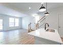 Open-concept living area with hardwood floors, natural light, and a view of the staircase at 357 Church St # 61, Wendell, NC 27591