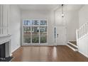 Bright living room featuring vaulted ceilings, fireplace, large windows, and hardwood floors at 3908 Sturbridge Dr, Durham, NC 27713