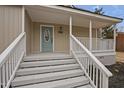 Inviting covered front porch with white railings and steps leading to a blue front door at 408 Charlotte Ave, Sanford, NC 27330