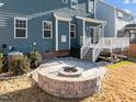 Backyard with a stone firepit, deck, and blue siding on the house at 5121 Windmere Chase Dr, Raleigh, NC 27616