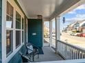 A cozy covered front porch features two chairs, white railings, and an inviting atmosphere at 5121 Windmere Chase Dr, Raleigh, NC 27616