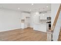 Bright, open-concept living space with wood flooring and a modern kitchen island at 602 Hyperion Aly, Wake Forest, NC 27587