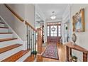Elegant foyer with hardwood floors, staircase, and natural light streaming through the front door at 6205 Roles Saddle Dr, Rolesville, NC 27571