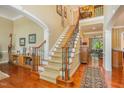 Grand foyer with hardwood floors, a carpeted staircase, and elegant lighting, creating a welcoming first impression at 101 Tussled Ivy Way, Cary, NC 27513