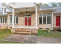 Welcoming covered front porch with double red doors and brick steps at 1021 Reaves Dr, Chapel Hill, NC 27516