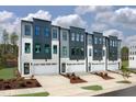 Modern townhome exteriors with white garages, landscaping, and contemporary dark trim at 10622 Pleasant Branch Dr # 8, Raleigh, NC 27614