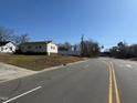 A single-story home with white siding and a clear blue sky in the background, located on a well-maintained street at 112 Lewis St, Oxford, NC 27565