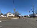 This depicts the home's positioning on a busy street, under a bright, cloudless sky, with a traffic light at 112 Lewis St, Oxford, NC 27565