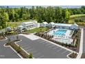Aerial view of community amenities including a pool, clubhouse, playground, parking, and lush green spaces at 1210 Tannin Dr, Durham, NC 27713
