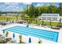 Aerial shot of a large community pool surrounded by greenery, lounge chairs, umbrellas, and a clubhouse at 1210 Tannin Dr, Durham, NC 27713