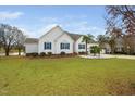 Charming white home with blue shutters, a well-manicured lawn, and mature trees in a residential neighborhood at 123 Glasgow Dr, Clayton, NC 27520