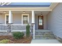 Inviting front porch with stone accents, wood door, and space for seating, perfect for enjoying the outdoors at 130 Scarlet Oak Ln, Chapel Hill, NC 27516