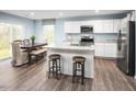 Eat-in kitchen featuring stainless steel appliances, white cabinetry, and a center island with seating at 133 Cavalier Rider Run, Wendell, NC 27591
