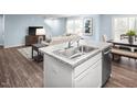 Open concept kitchen with a breakfast bar flowing into the living and dining areas at 133 Cavalier Rider Run, Wendell, NC 27591