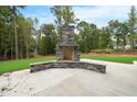 Stone outdoor fireplace with a concrete patio at 1600 Sweetwater Ln, Raleigh, NC 27610