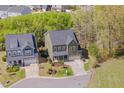 Aerial view of a two-story home with a manicured front lawn and a two-car garage at 1680 Mint River Dr, Apex, NC 27502