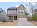 Lovely two-story home with an inviting front porch and well-manicured lawn and landscaping at 1680 Mint River Dr, Apex, NC 27502