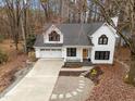 Charming front exterior showcasing a two-story white house with a two car garage and landscaping at 202 Oxford Hills Dr, Chapel Hill, NC 27514