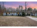 View of the home's exterior showcasing the home's architectural lines, simple landscaping and mature trees at 2118 Timberlake Dr, Raleigh, NC 27604