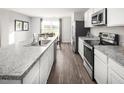 Well-lit kitchen featuring stainless steel appliances, granite countertops, and hardwood floors at 213 Suburban Meadow Pass, Wendell, NC 27591