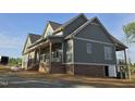 Beautiful two-story home with gray siding and a brick foundation and deck at 2833 Faucette Ln, Burlington, NC 27217