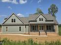 Charming two-story home with a covered front porch, complemented by brick accents and a well-manicured lawn at 2833 Faucette Ln, Burlington, NC 27217