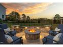Outdoor fire pit area with stone surround and comfortable seating, perfect for entertaining guests and enjoying the serene view at 3215 Jones Lake Rd, Fuquay Varina, NC 27526