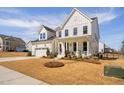 Charming two-story white farmhouse-style home with a manicured lawn and a two-car garage at 3215 Jones Lake Rd, Fuquay Varina, NC 27526