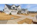 View of modern white farmhouse-style homes, showcasing neighborhood charm and curb appeal at 3215 Jones Lake Rd, Fuquay Varina, NC 27526