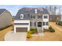 Charming two-story home with stone and painted brick exterior, dormer windows, and a driveway at 329 Royal Delta Dr, Cary, NC 27519