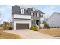 Beautiful two-story home featuring a stone facade, white painted brick, and a driveway at 329 Royal Delta Dr, Cary, NC 27519