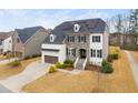 Elegant two-story home with a stone facade, painted brick, dormer windows, and a driveway at 329 Royal Delta Dr, Cary, NC 27519